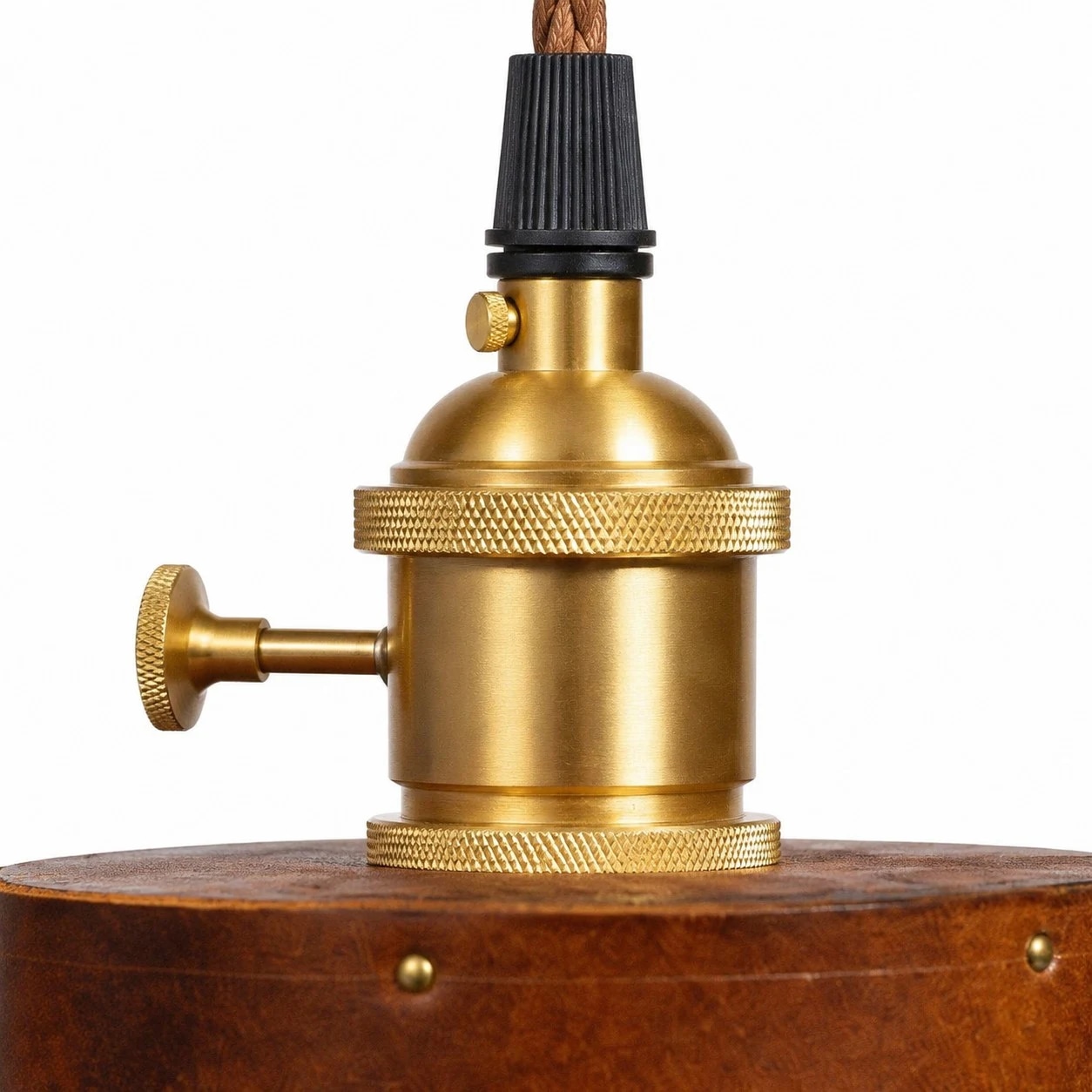 Gros plan sur la douille en laiton d'une lampe suspendue en cuir marron