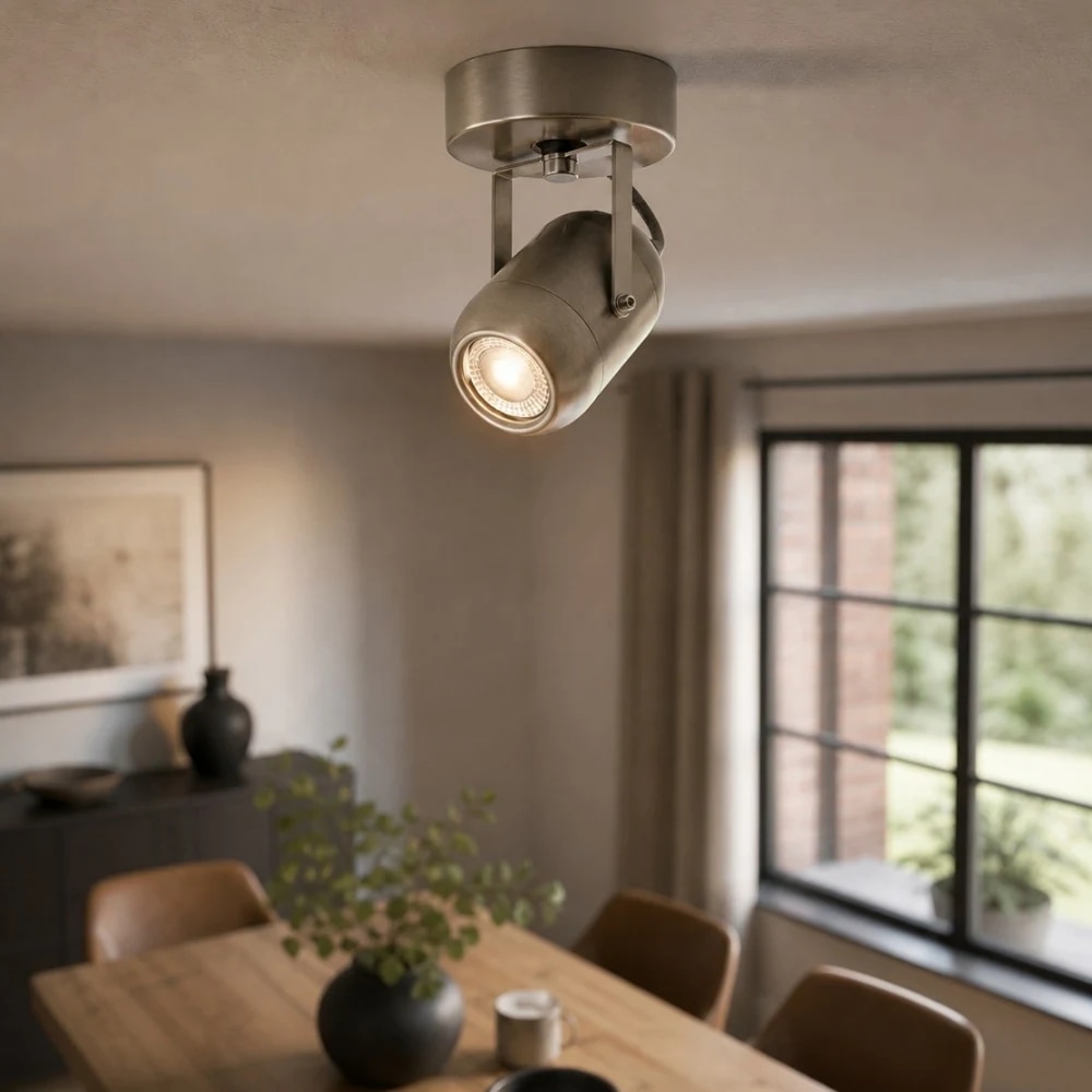 Applique murale LED réglable en nickel sable utilisée comme éclairage d'accentuation dans une salle à manger