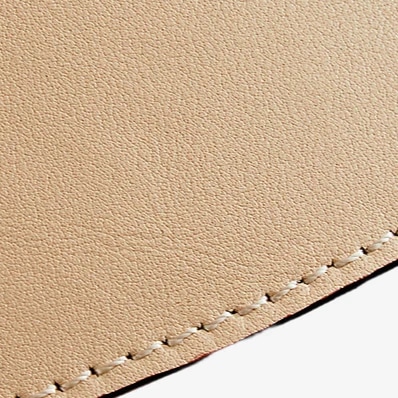 Gros plan sur la texture du cuir et le bord cousu de l'abat-jour suspendu