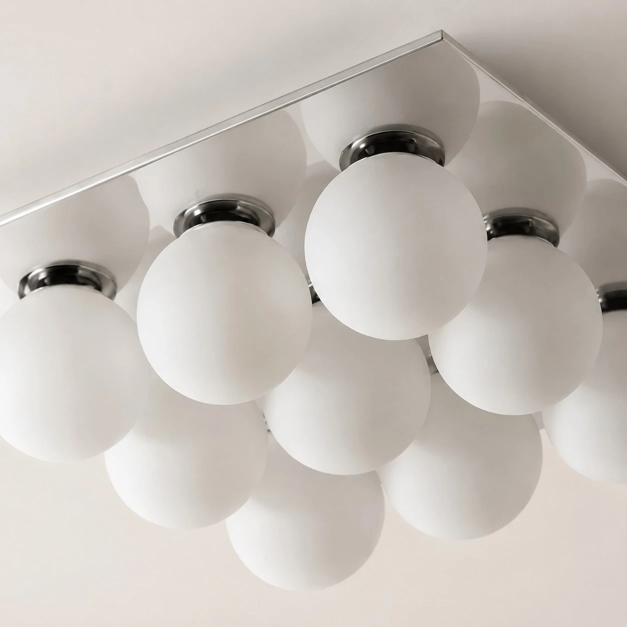 Globi in vetro satinato e supporti cromati per la lampada da soffitto.
