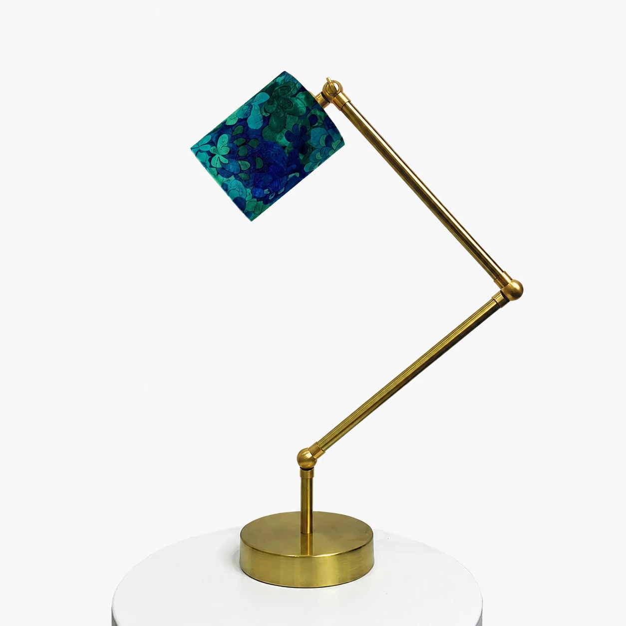 Vue complète de la lampe de table réglable couleur laiton avec abat-jour bleu-vert à motifs floraux