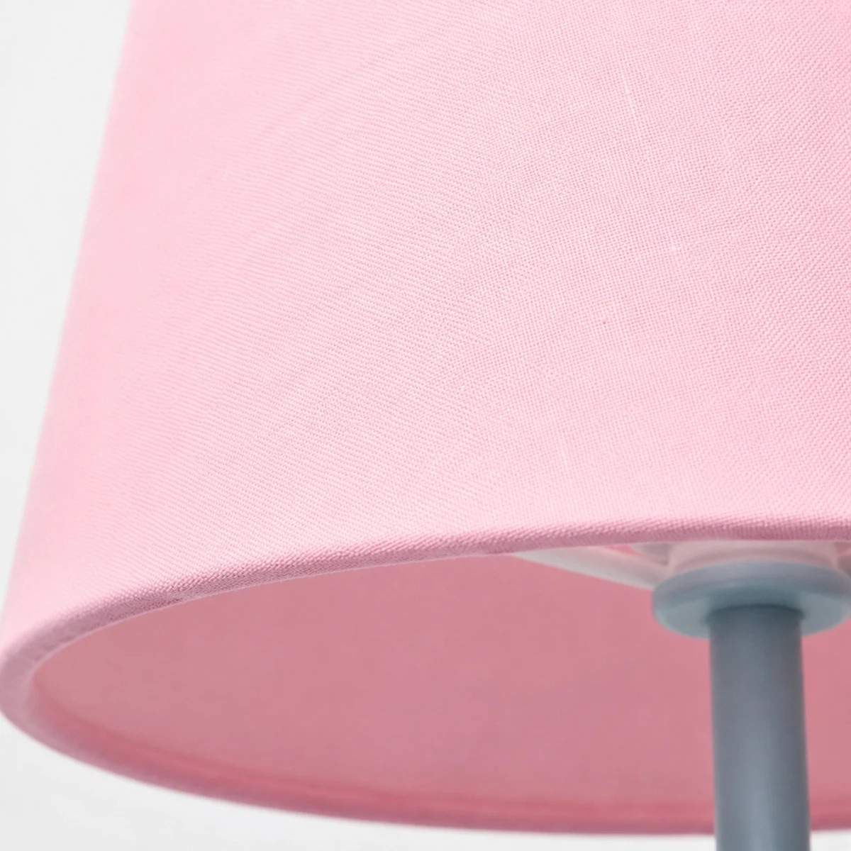 Borde inferior de la pantalla de tela rosa y tallo de metal.