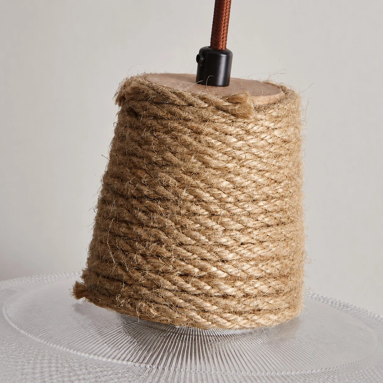 Detailopname van de geweven touwkraag en het bruine ophangkoord.