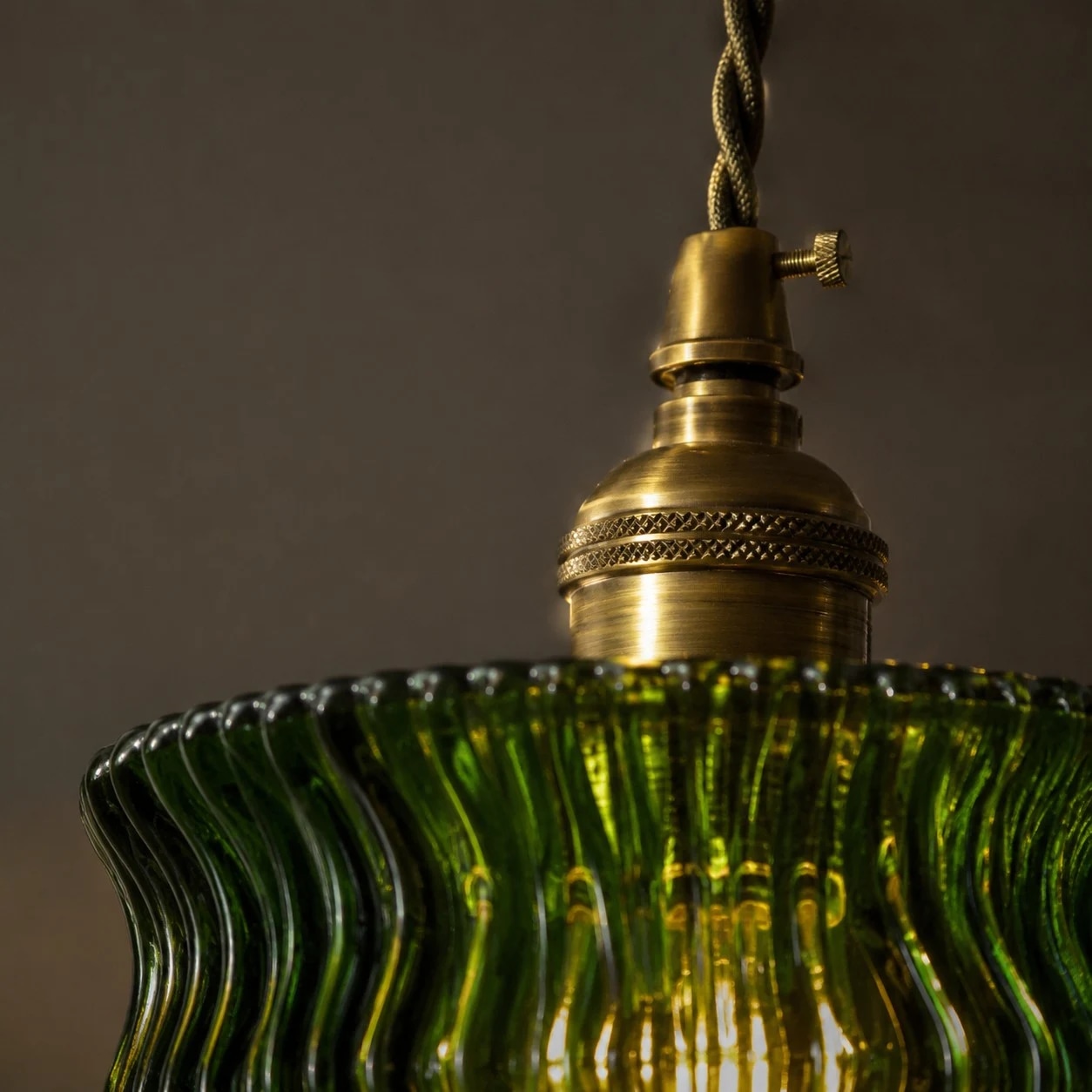 Détail de la tête de lampe couleur laiton au-dessus de l'abat-jour en verre vert