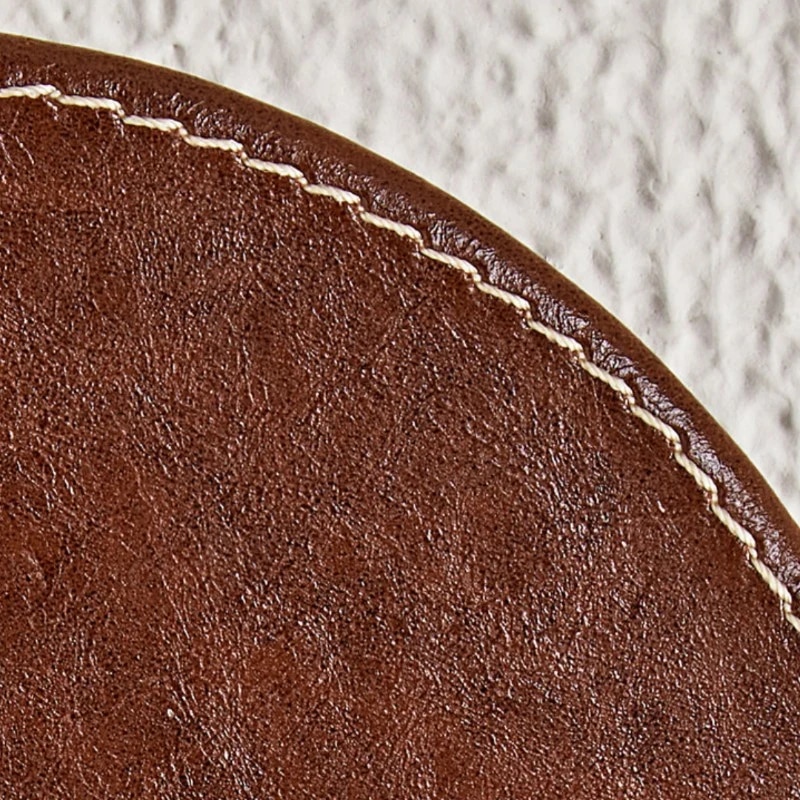 Texture cuir marron et détails de couture sur les bords