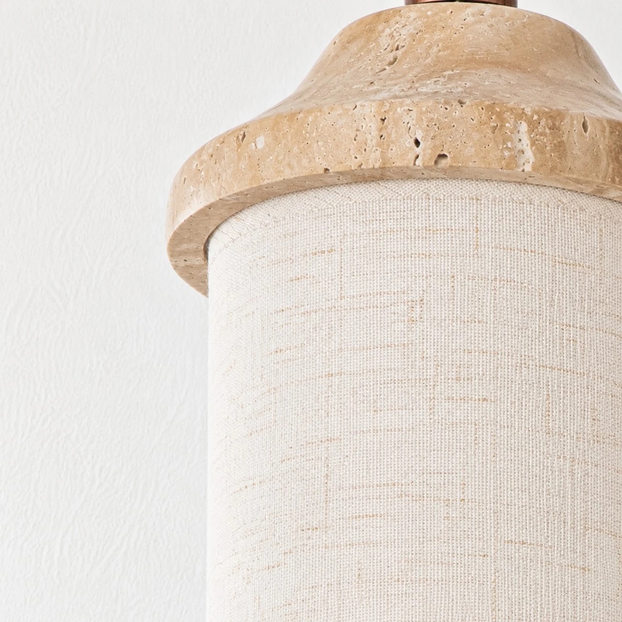 Fabric shade texture beneath the stone cap