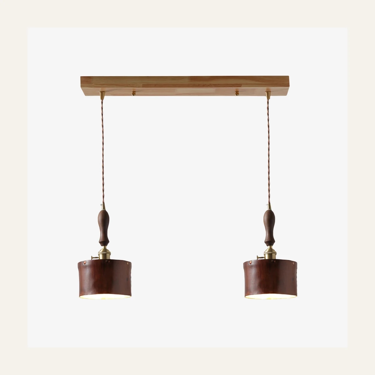 Suspension double marron avec abat-jour en cuir.