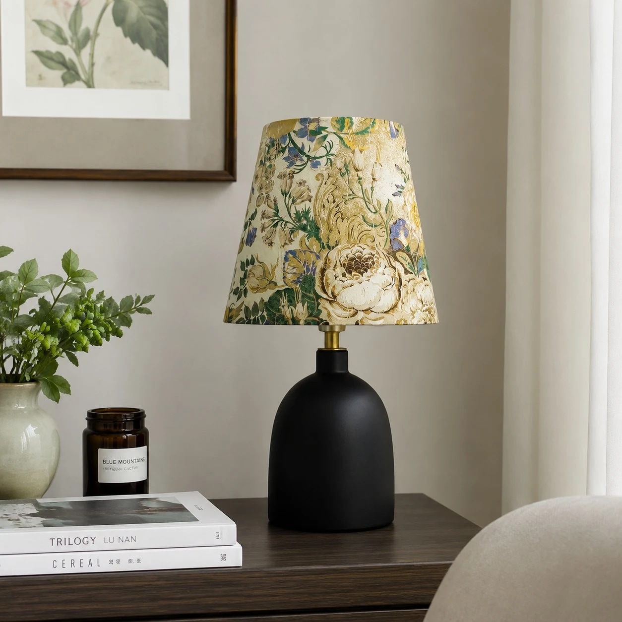 Lámpara de mesa floral colocada sobre una mesita de noche.