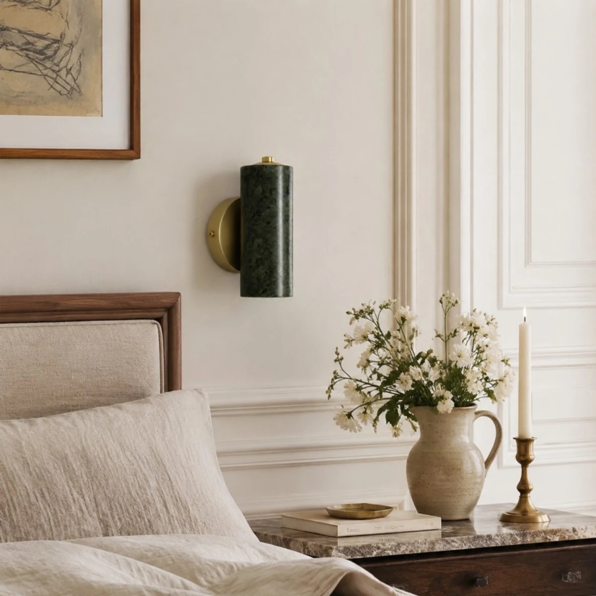 Applique murale en jade vert placée au-dessus d'une table de chevet ornée de fleurs