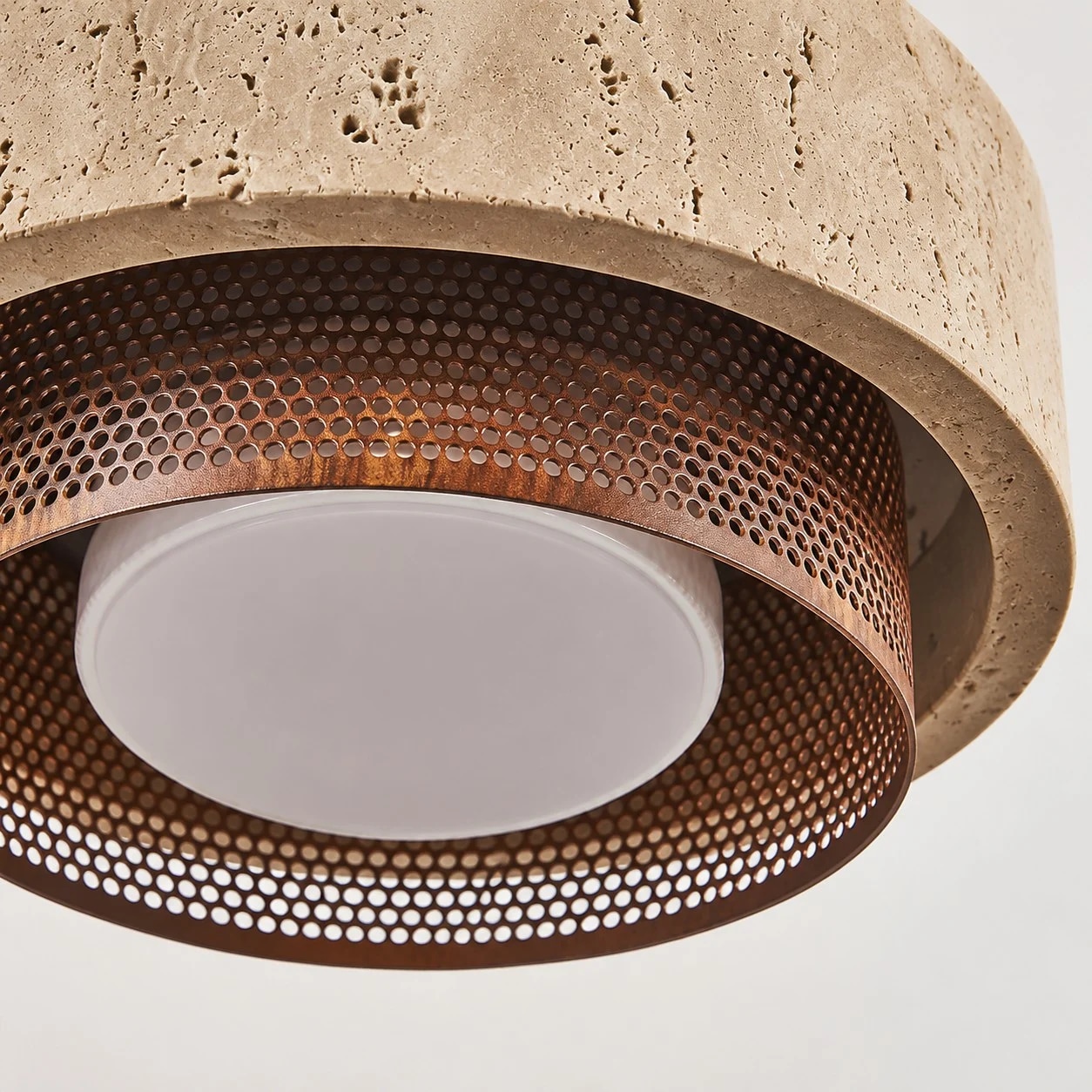 close view of rust color mesh shade and diffuser under travertine stone
