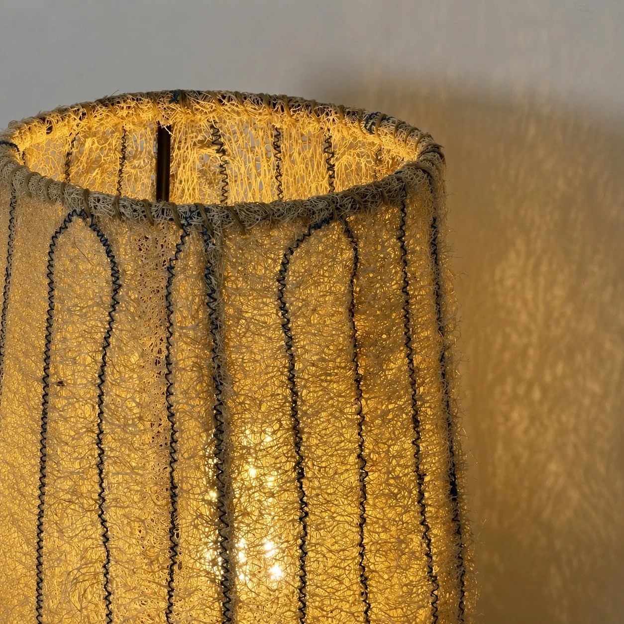 Gros plan sur la texture lumineuse de l'abat-jour en fibres tissées naturelles