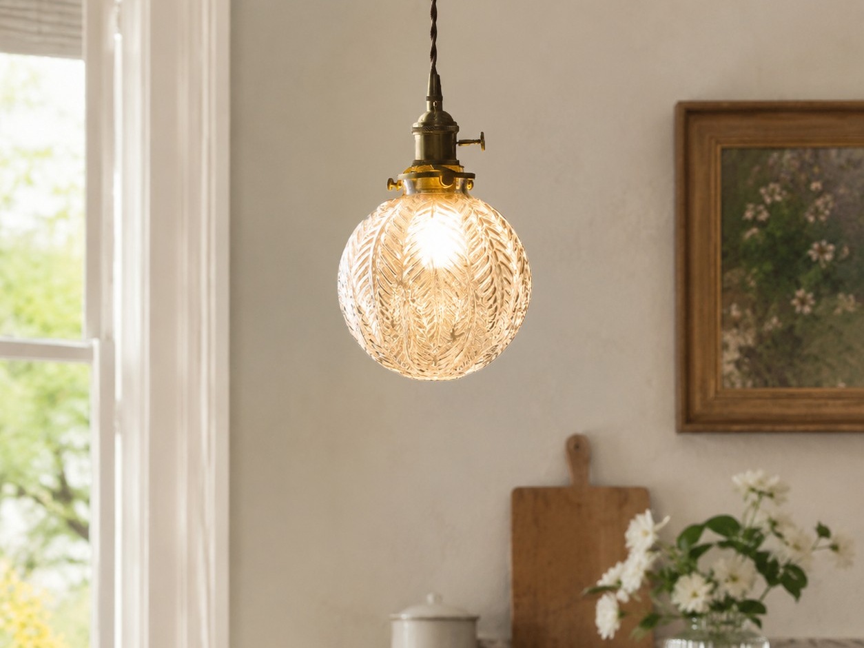 Suspension en laiton et verre transparent installée au-dessus d'une petite table à manger