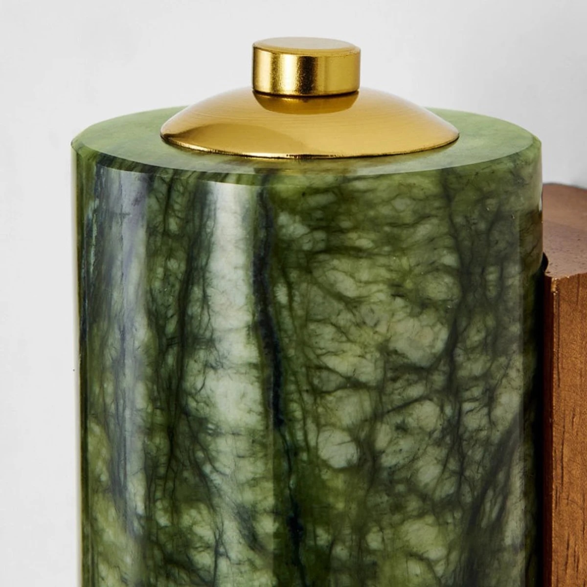 Gros plan sur la texture d'un cylindre de jade vert et son capuchon en laiton