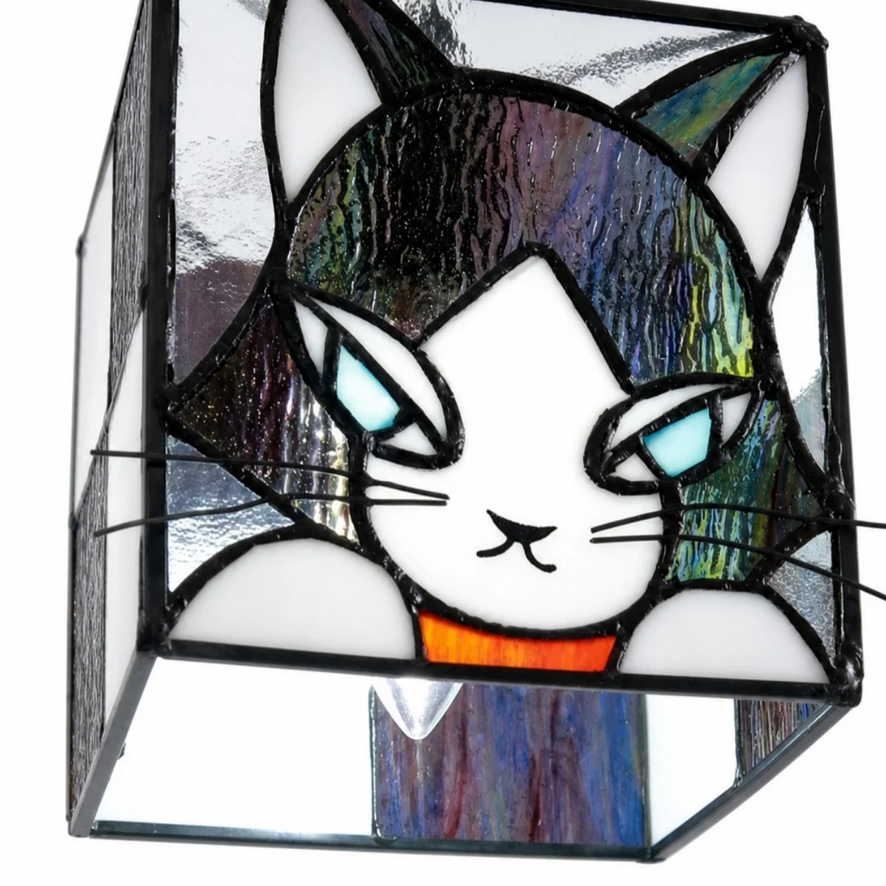 Detalle de la pantalla de vidriera con forma de cara de gato y el marco soldado.