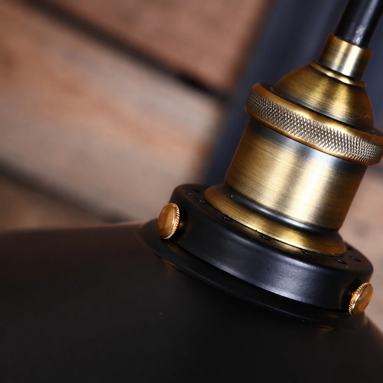 détail du support de lampe en bronze foncé et du capuchon en métal