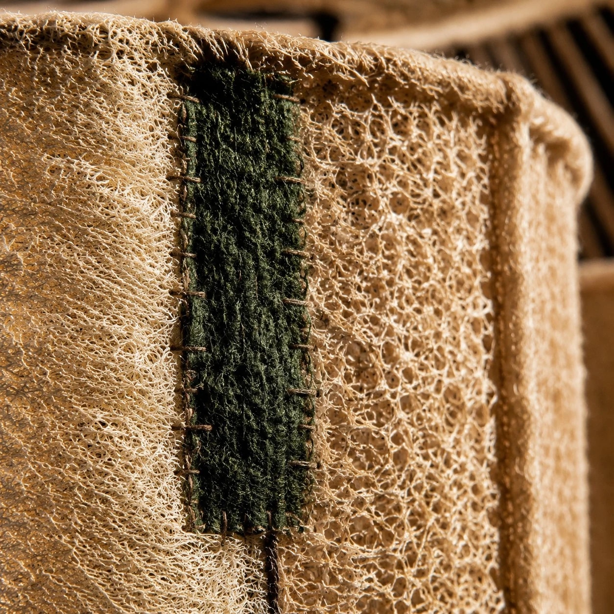 Gros plan sur la couture verte et le détail du bord tissé