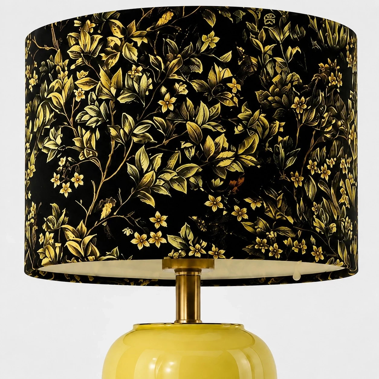 Paralume in tessuto nero con motivo floreale e decorazioni botaniche dorate.