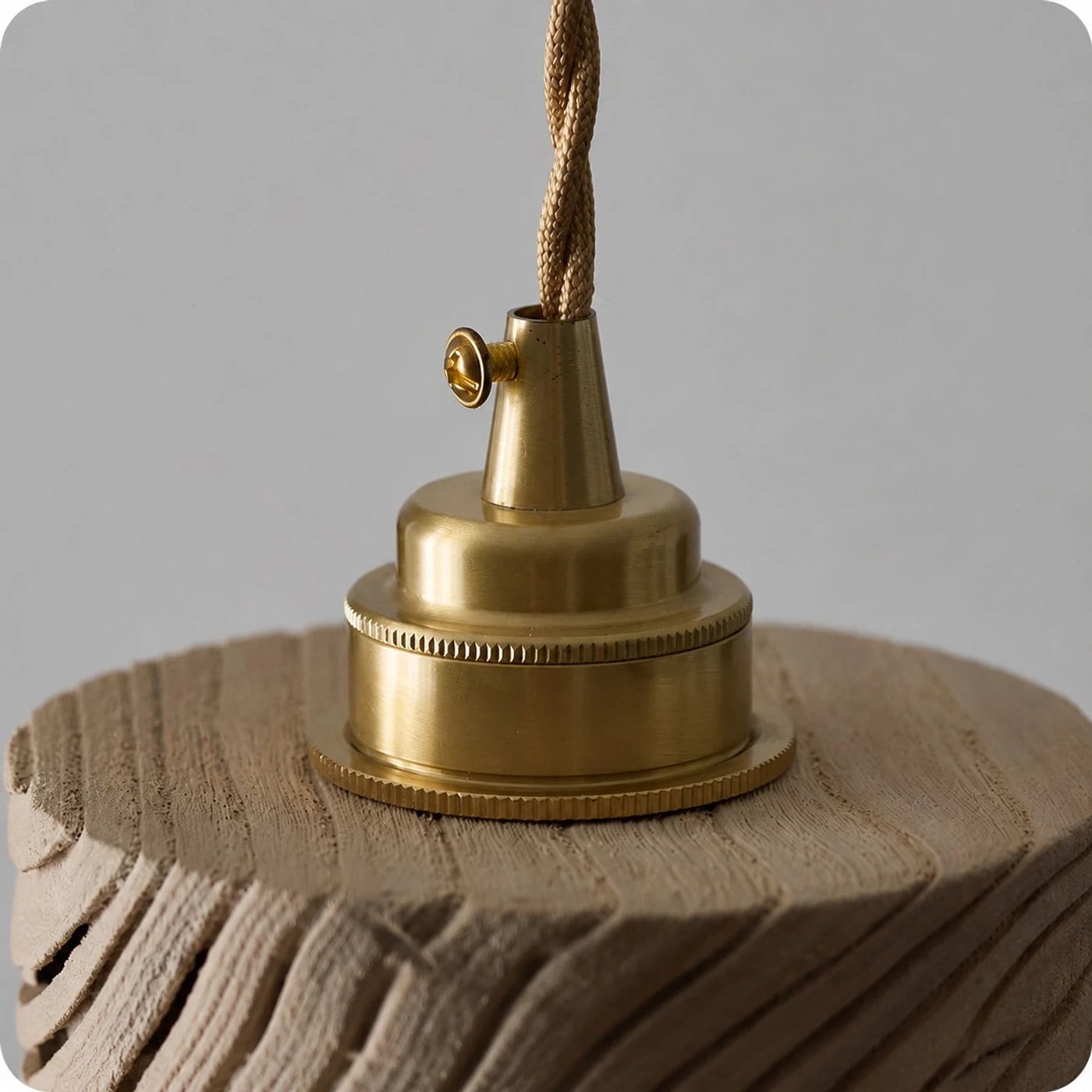 Pantalla de madera, herraje de metal tono latón, cable de suspensión trenzado.