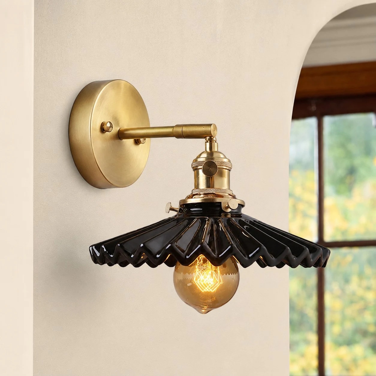 Lampada da parete in ceramica nera vicino ad una finestra ad arco
