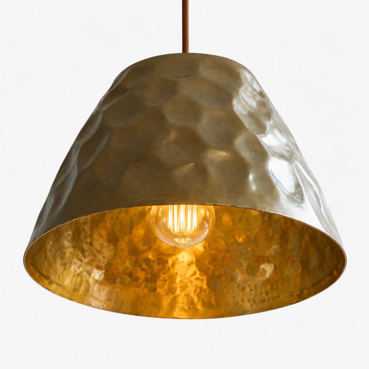 Warm golden interior of hammered brass pendant