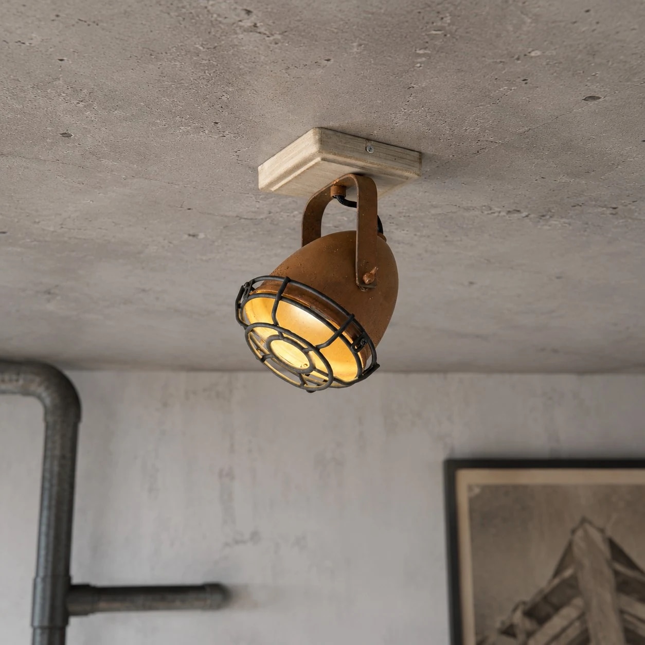 Spot encastrable rouillé installé et allumé au plafond.