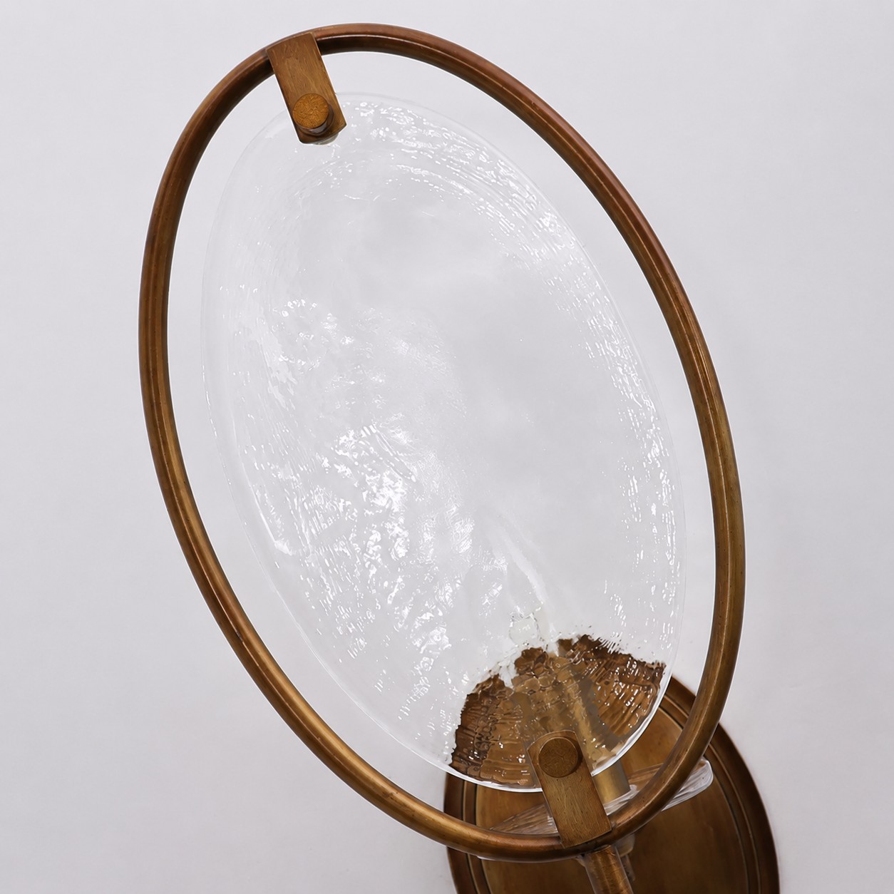 Détail d'une applique murale ovale en métal et verre