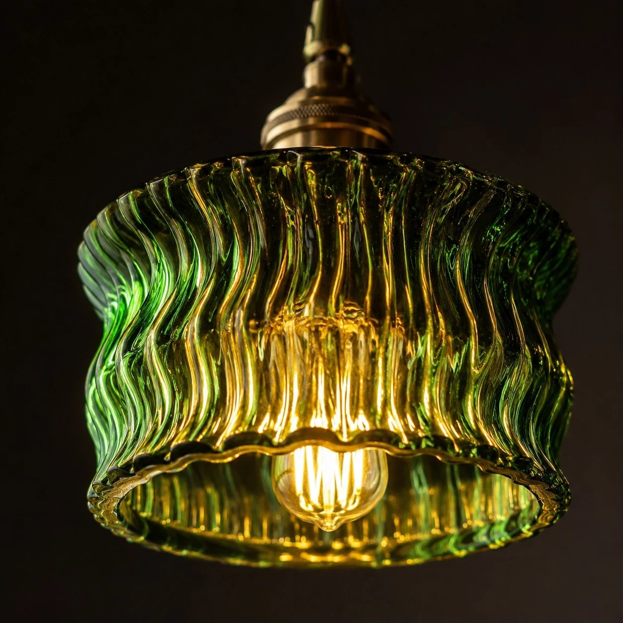 Une lumière chaude filtre à travers un abat-jour suspendu en verre ondulé vert