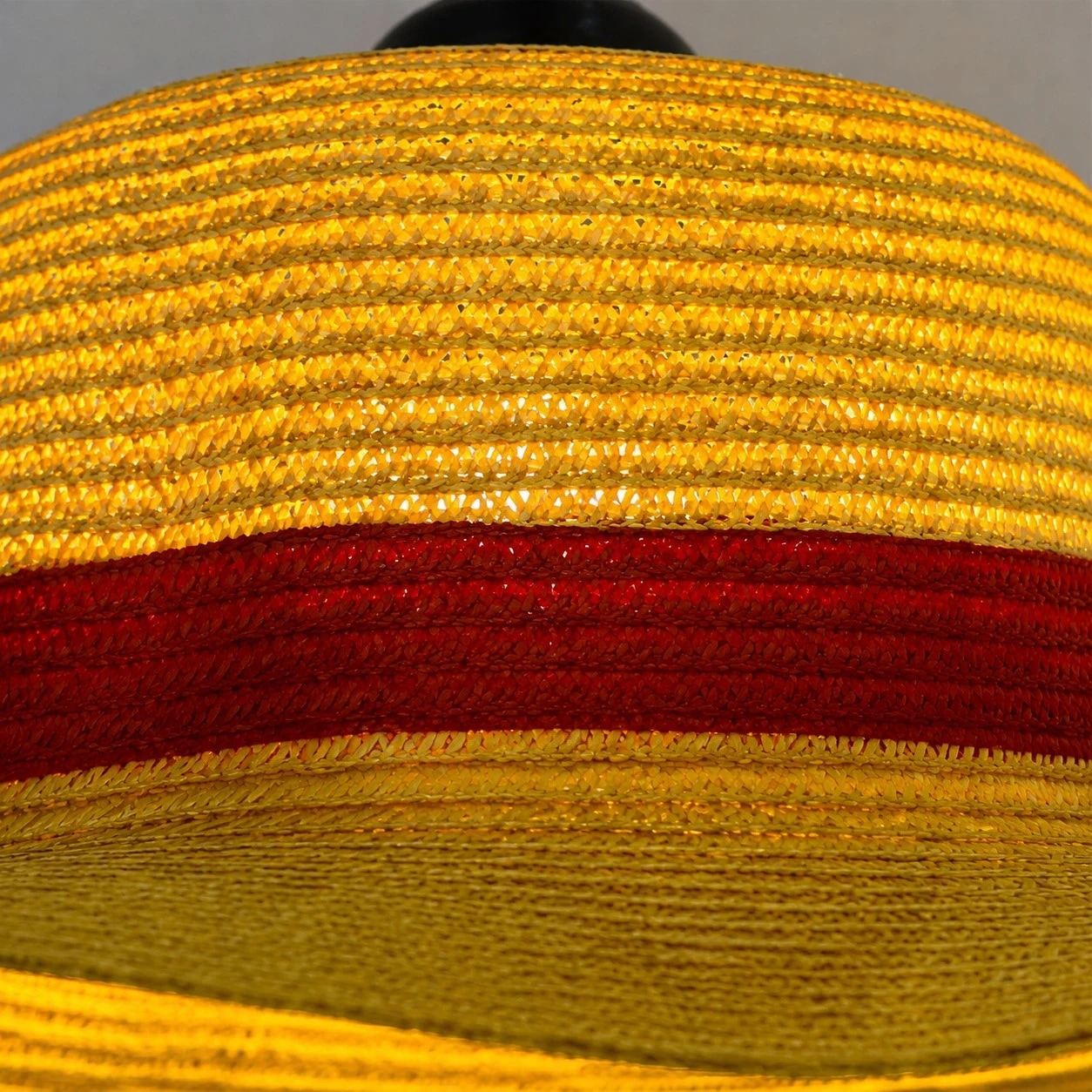 Layered straw texture, wide brim and a clean red accent band.