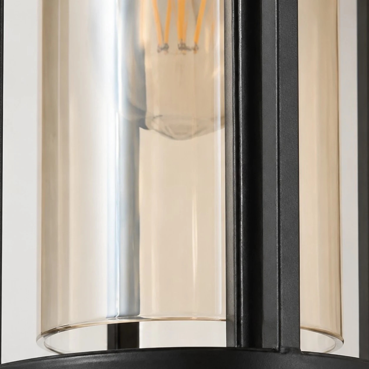 Gros plan sur le cylindre en verre ambré et l'ampoule E27 à lumière chaude à l'intérieur de la lanterne