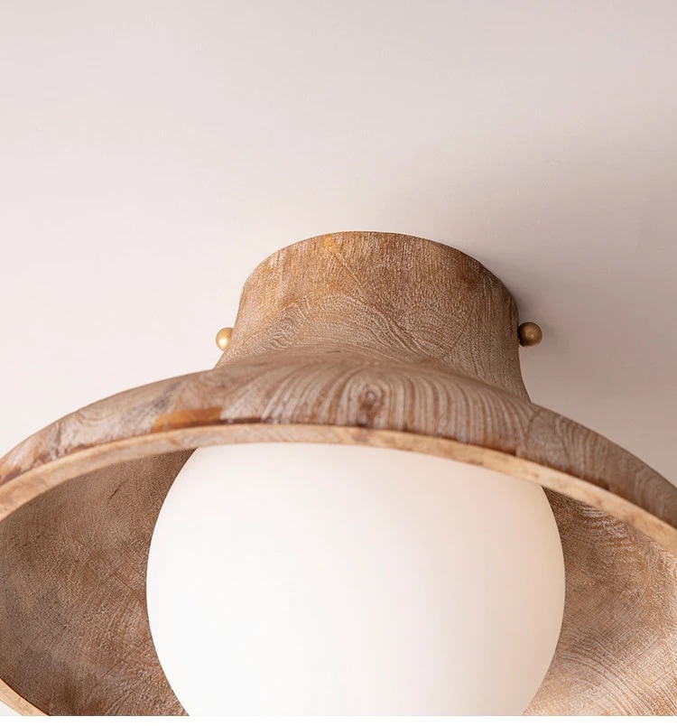 Gros plan sur le rebord en bois sculpté et le globe en verre opale