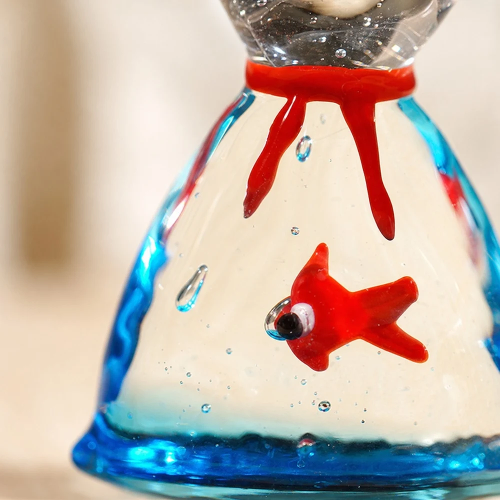 Detalle de un adorno de pez de cristal rojo y azul hecho a mano
