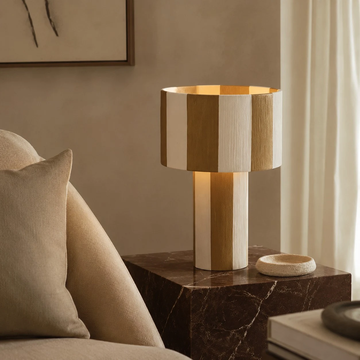 Lámpara de mesa tejida a rayas encendida junto a un sofá.