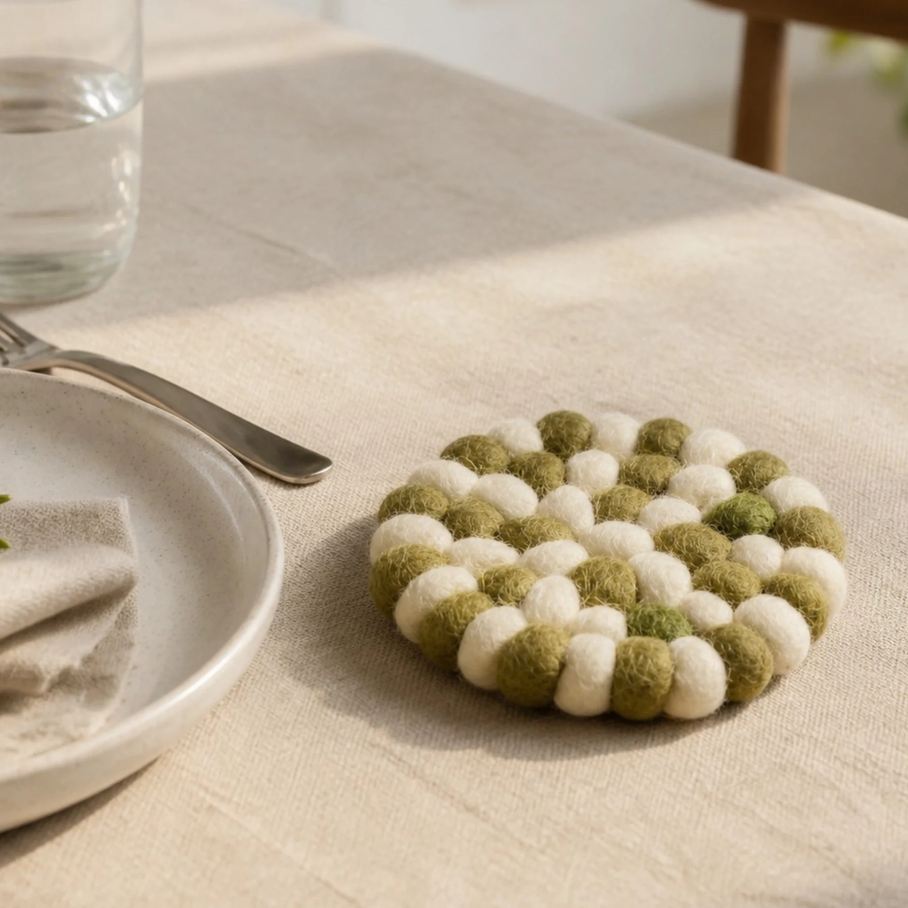 Sottobicchiere rotondo in feltro accanto ai bicchieri