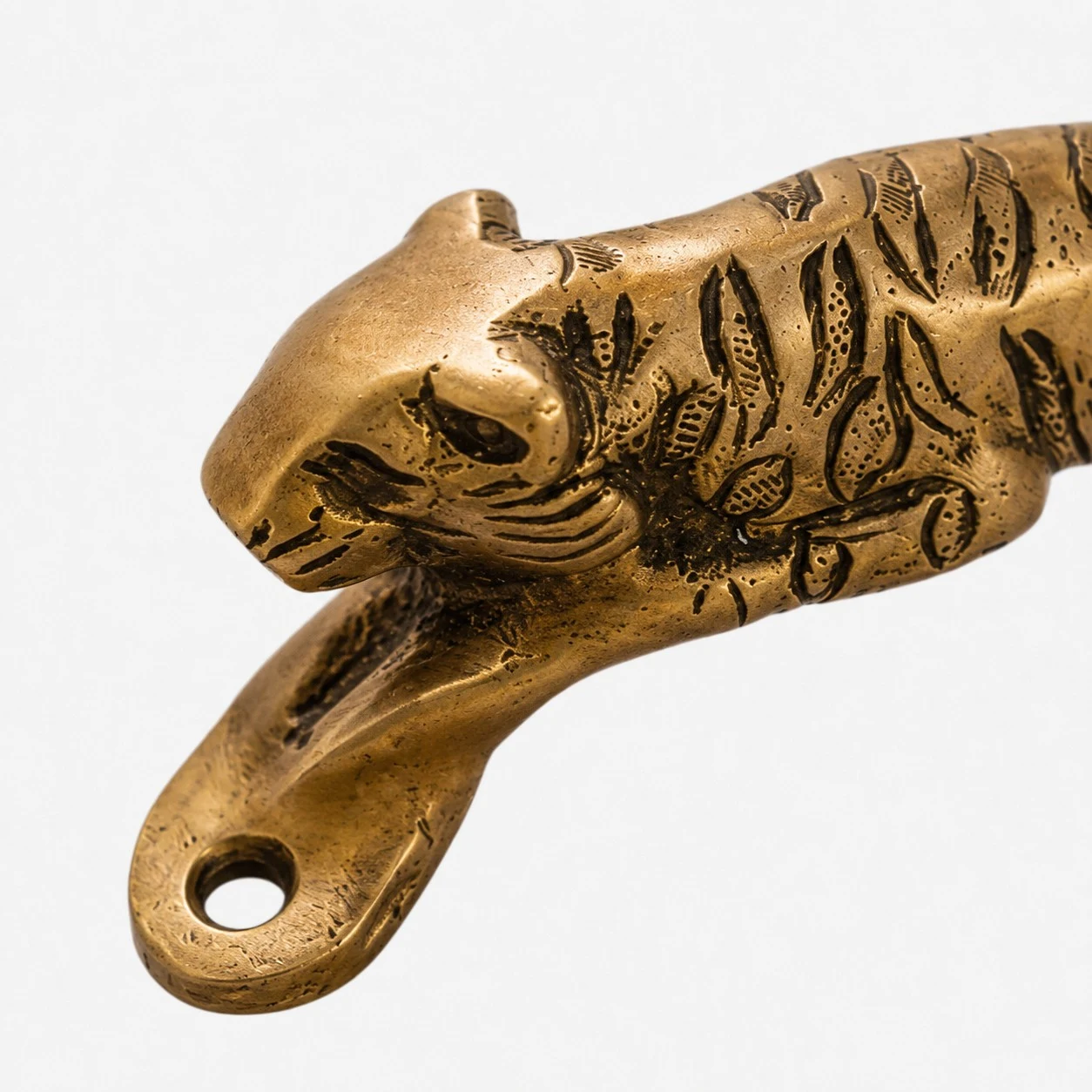 Manico in ottone lavorato a mano con texture e dettagli intagliati.