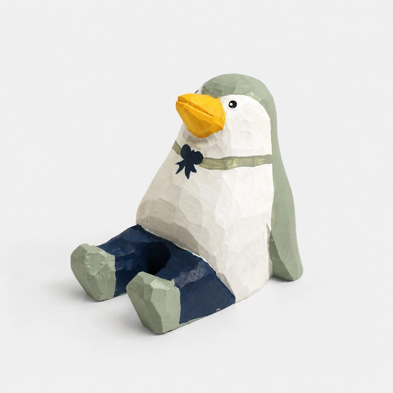 Supporto per telefono in legno intagliato a mano a forma di pinguino.