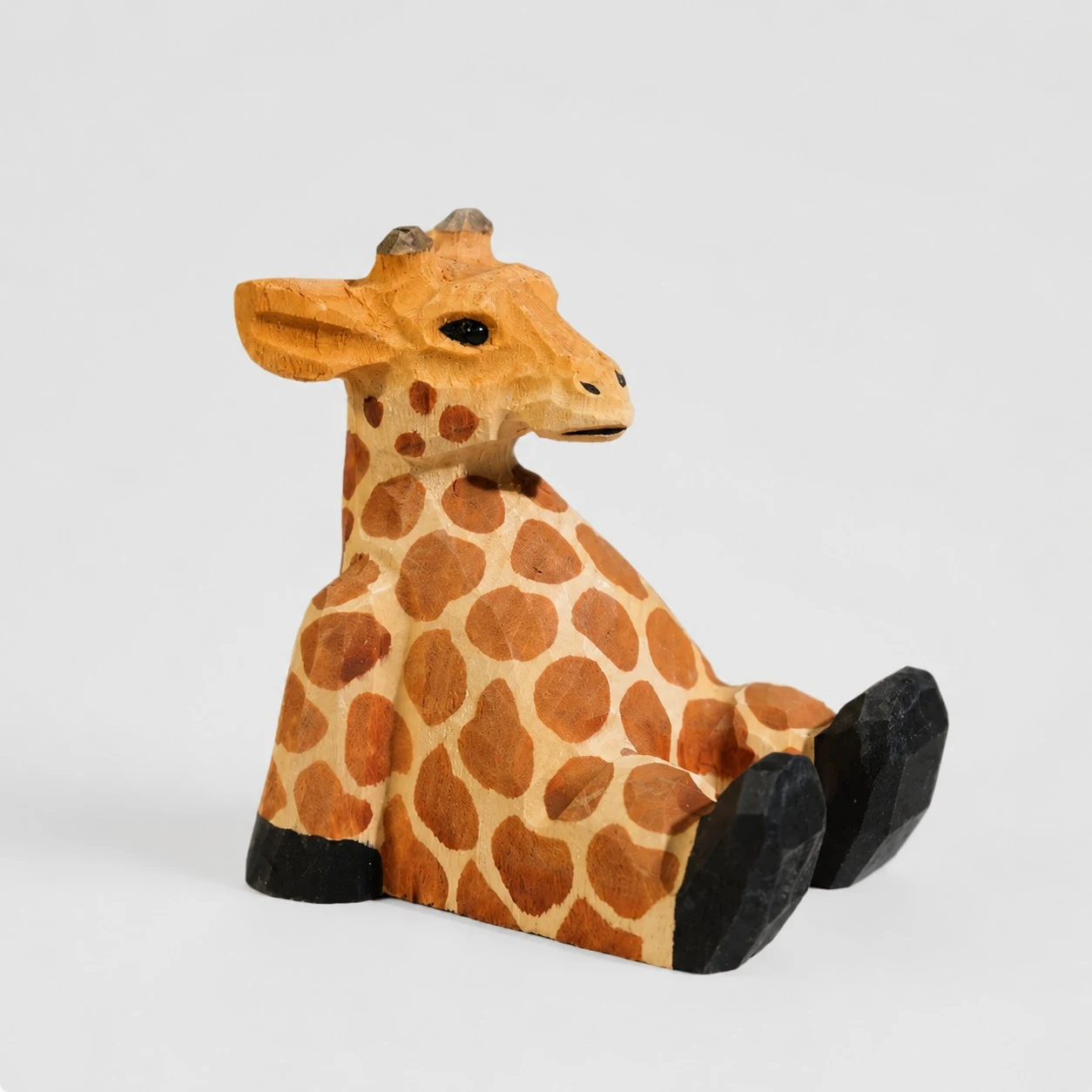 Supporto per telefono in legno intagliato a mano a forma di giraffa.