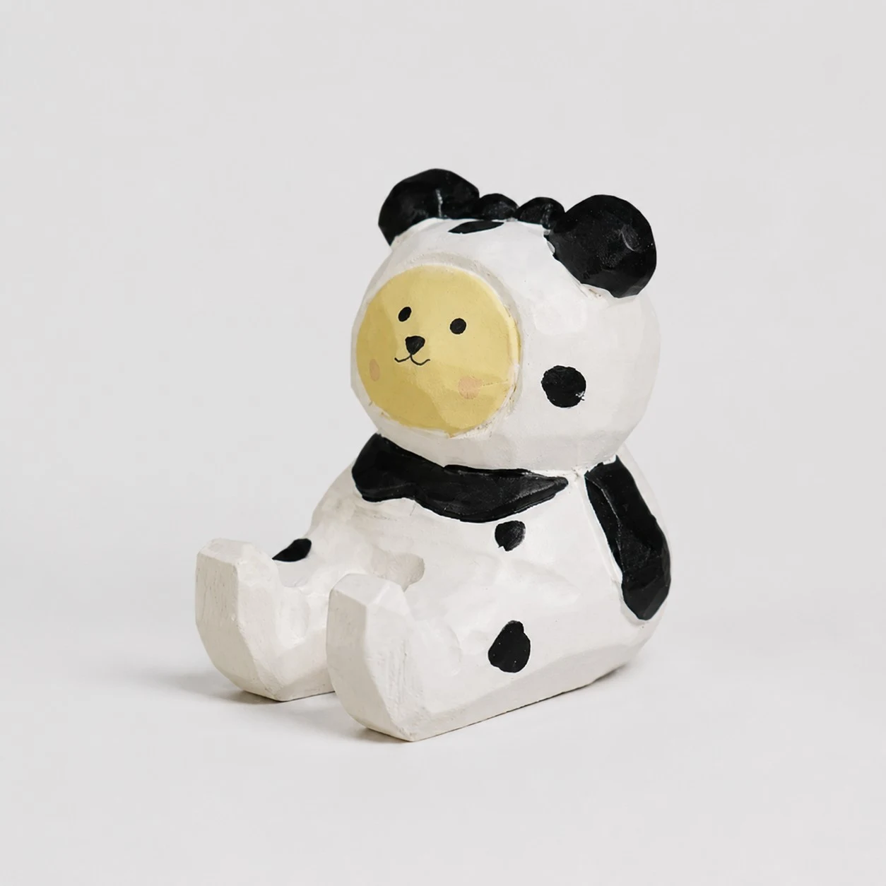 Supporto per telefono in legno intagliato a mano a forma di orso con costume da mucca.
