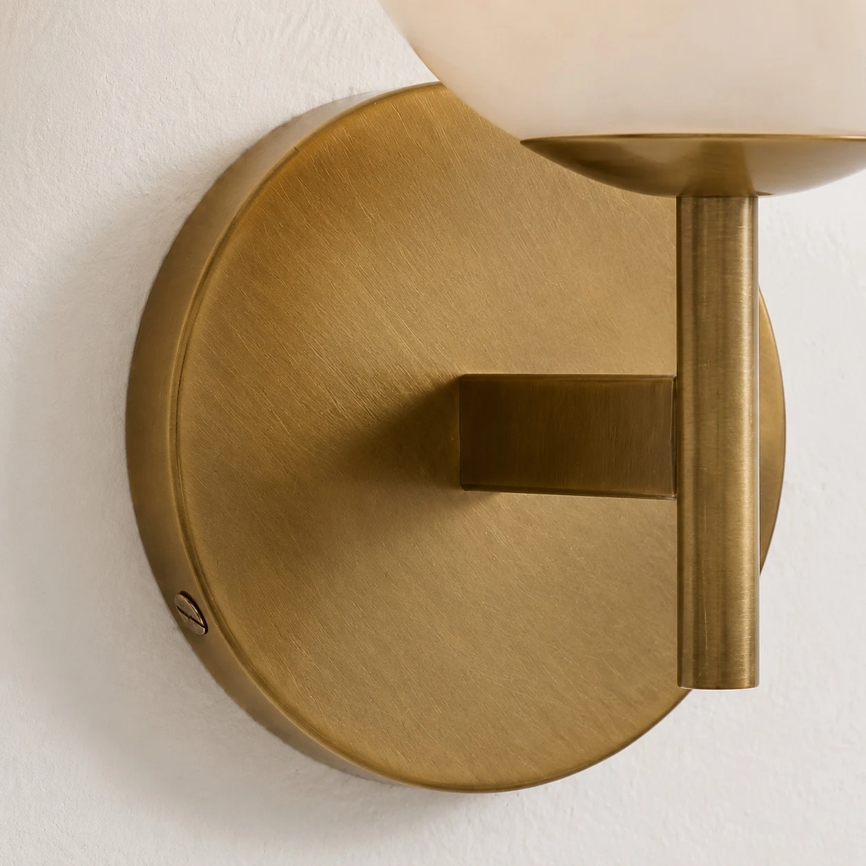 Close detail of brass round canopy and wall arm