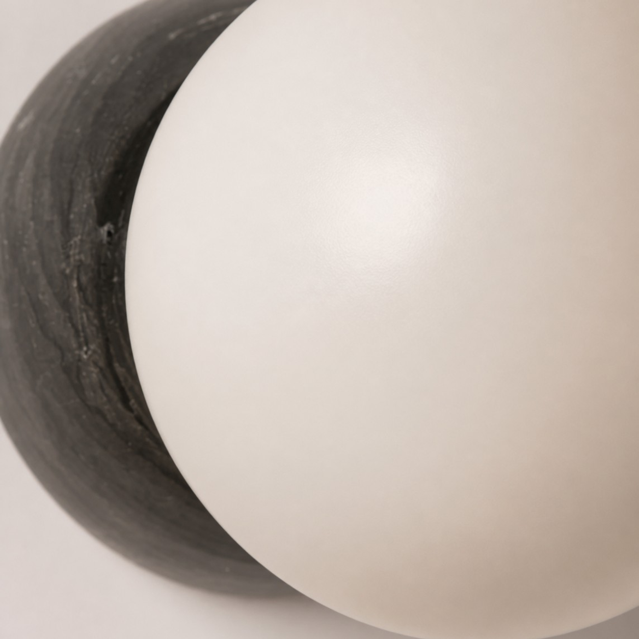 Primer plano del globo de cristal esmerilado opalino y la placa posterior de mármol negro