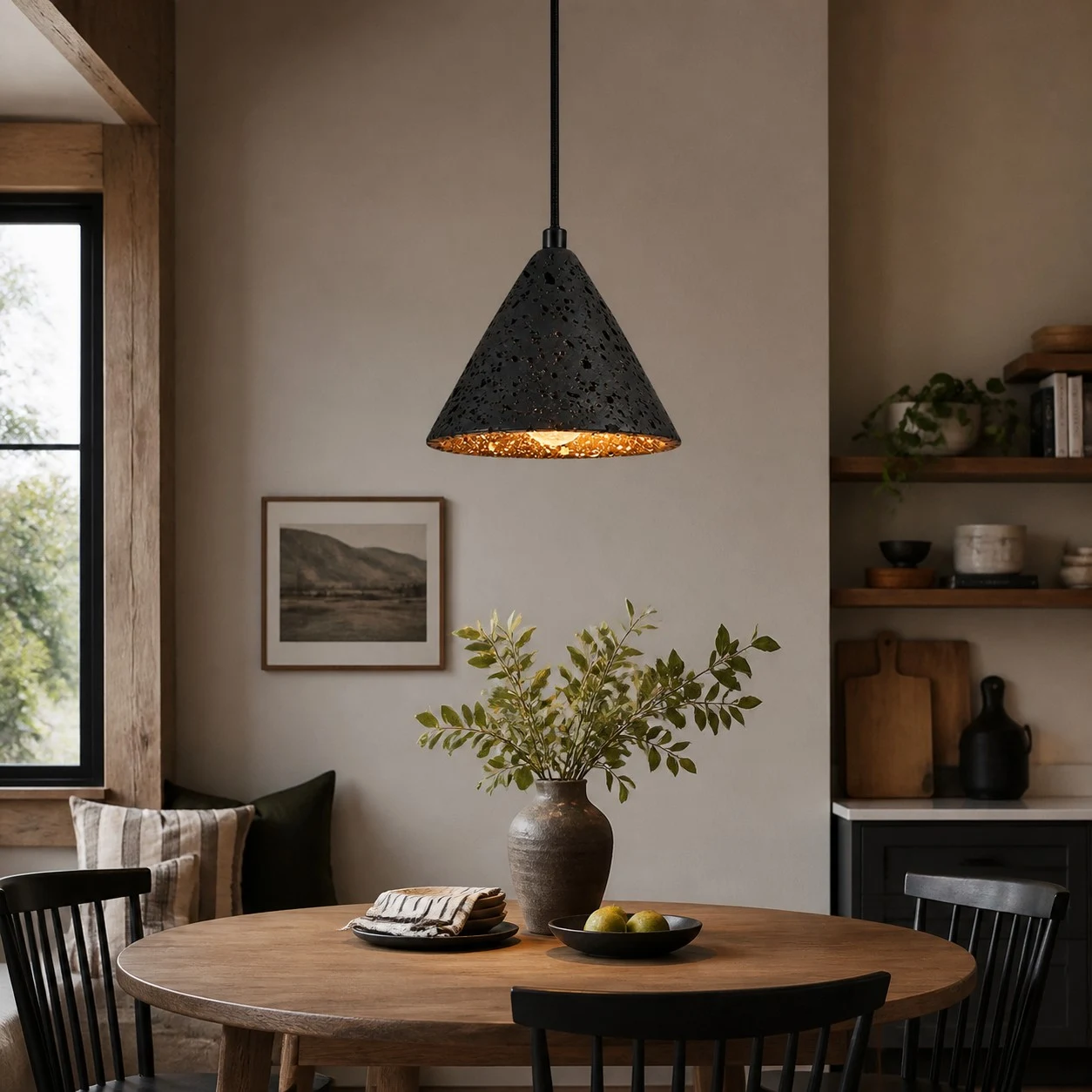 Colgante de piedra de lava negra sobre una cálida mesa de comedor de madera.