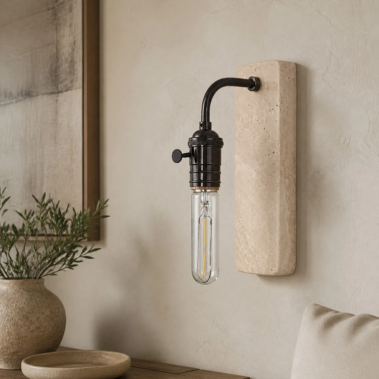 Black travertine wall sconce in a warm interior