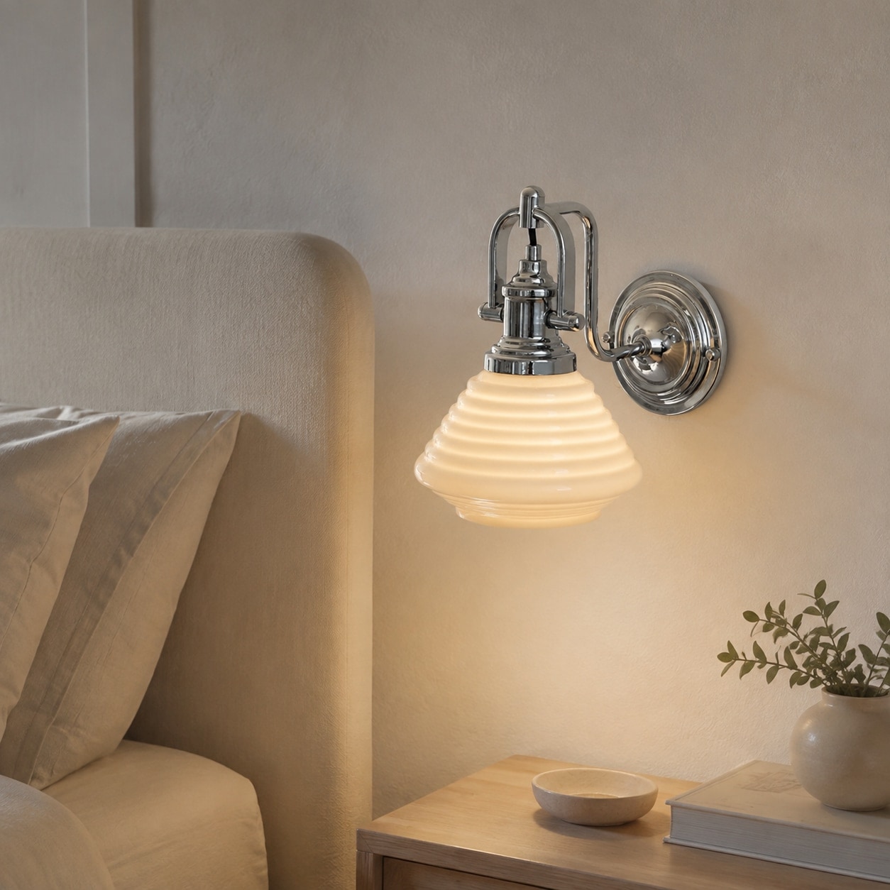 Krämig gul vägglampa i glas bredvid en säng