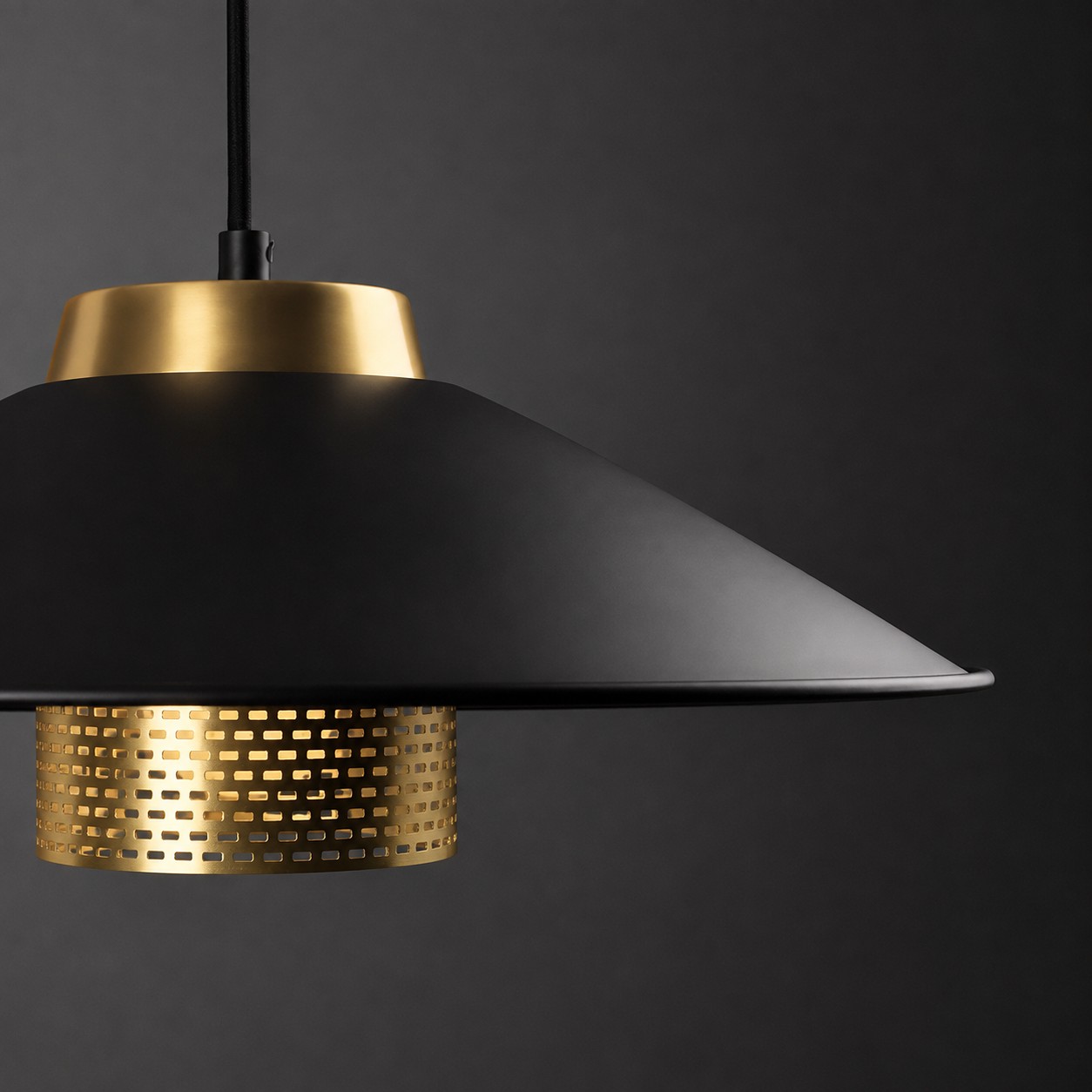 Vista en primer plano de la pantalla cónica negra mate y la estructura central de latón.