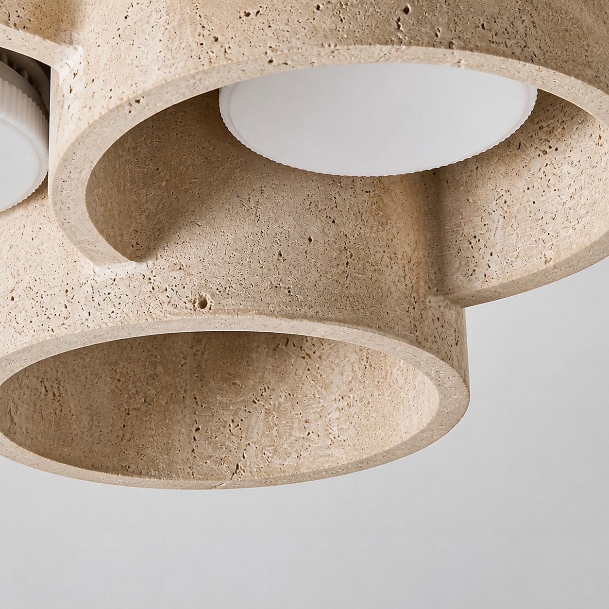 Gelaagd detail aan de onderkant van een travertin plafondlamp