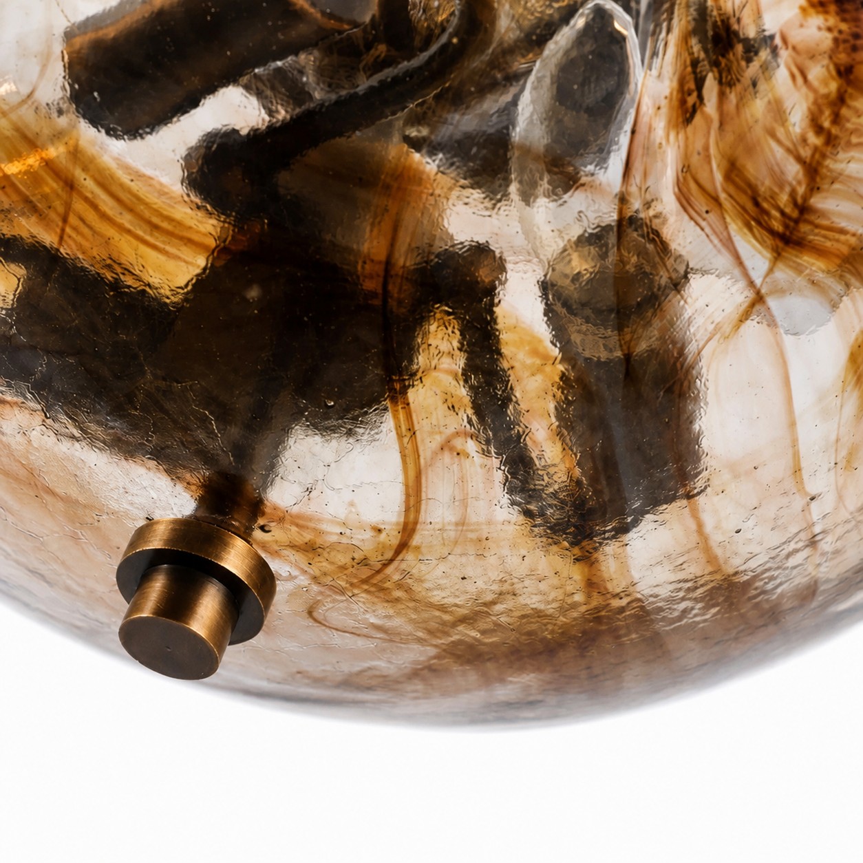 Gestructureerd amberkleurig glas en antiek messing sierelement.