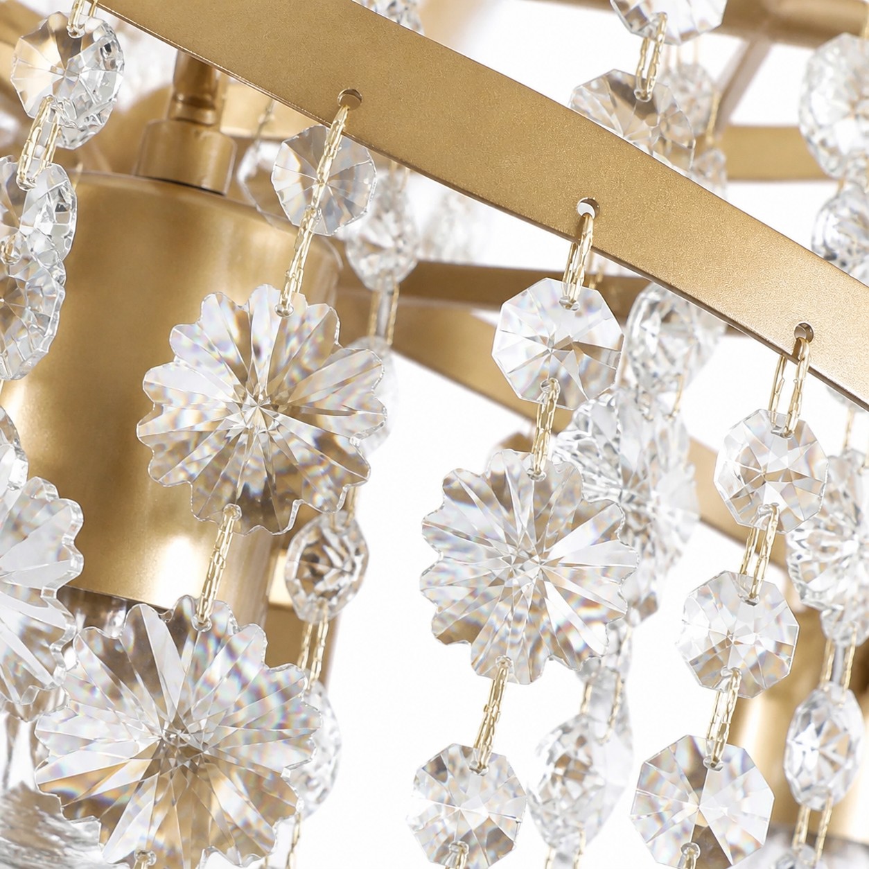 Flores de cristal facetado suspensas em uma estrutura dourada.