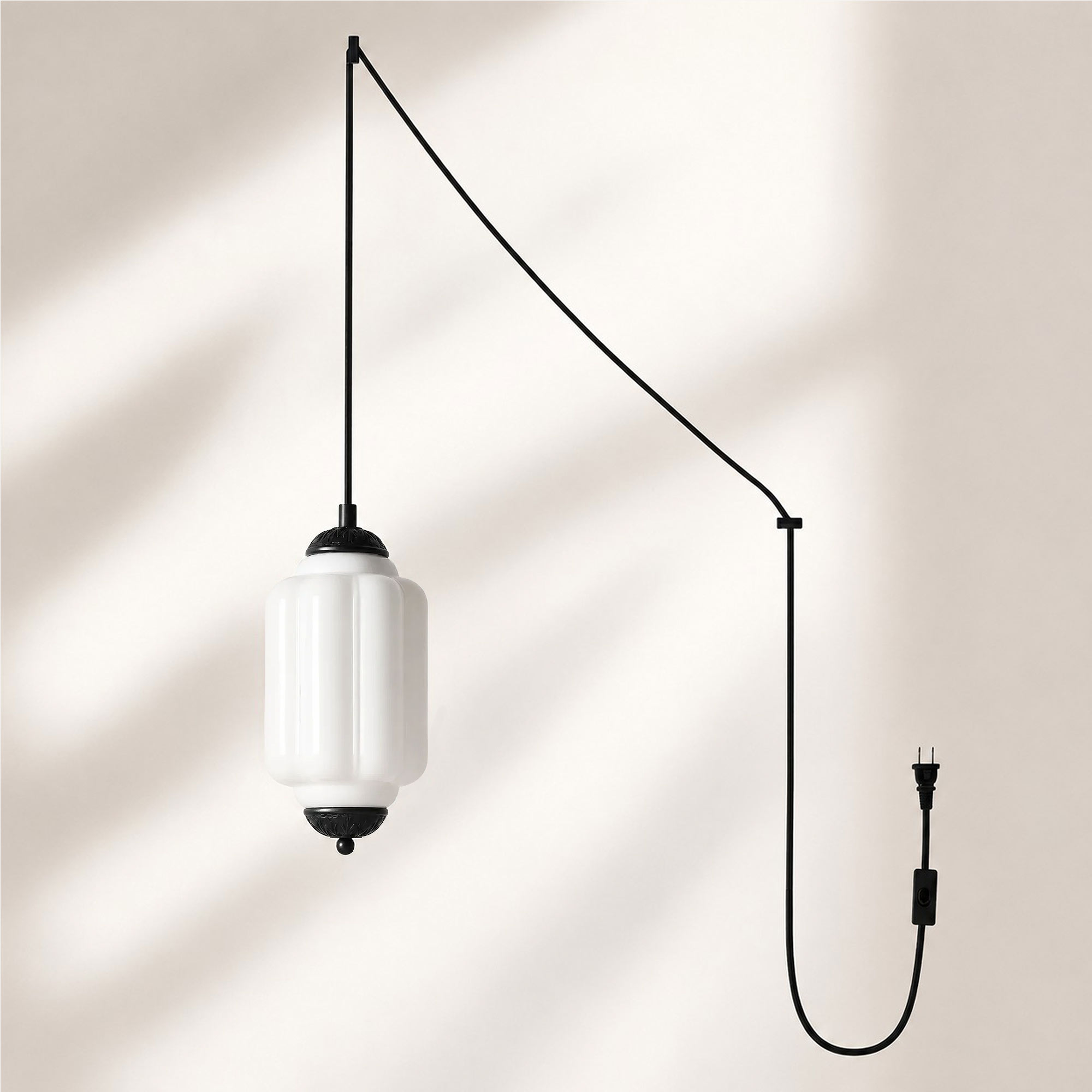 Lampadario a sospensione con finitura nera e paralume in vetro bianco.