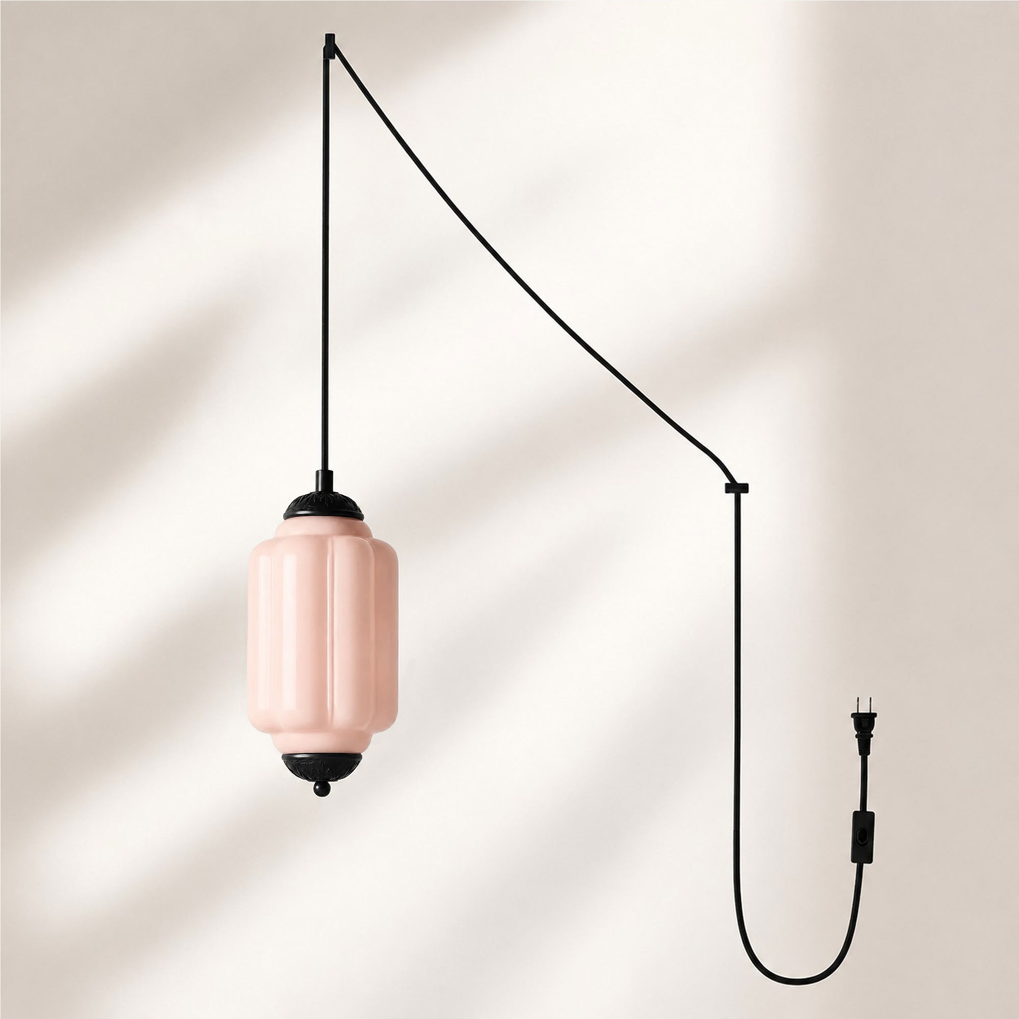 Lampadario con finitura nera e paralume in vetro rosa.