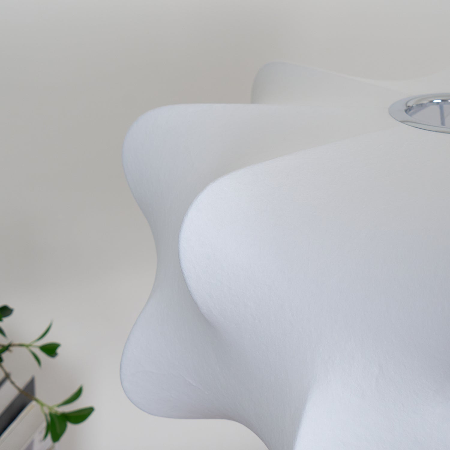 Gros plan sur l'abat-jour blanc de la suspension, révélant sa texture fine et ses bords légèrement incurvés.