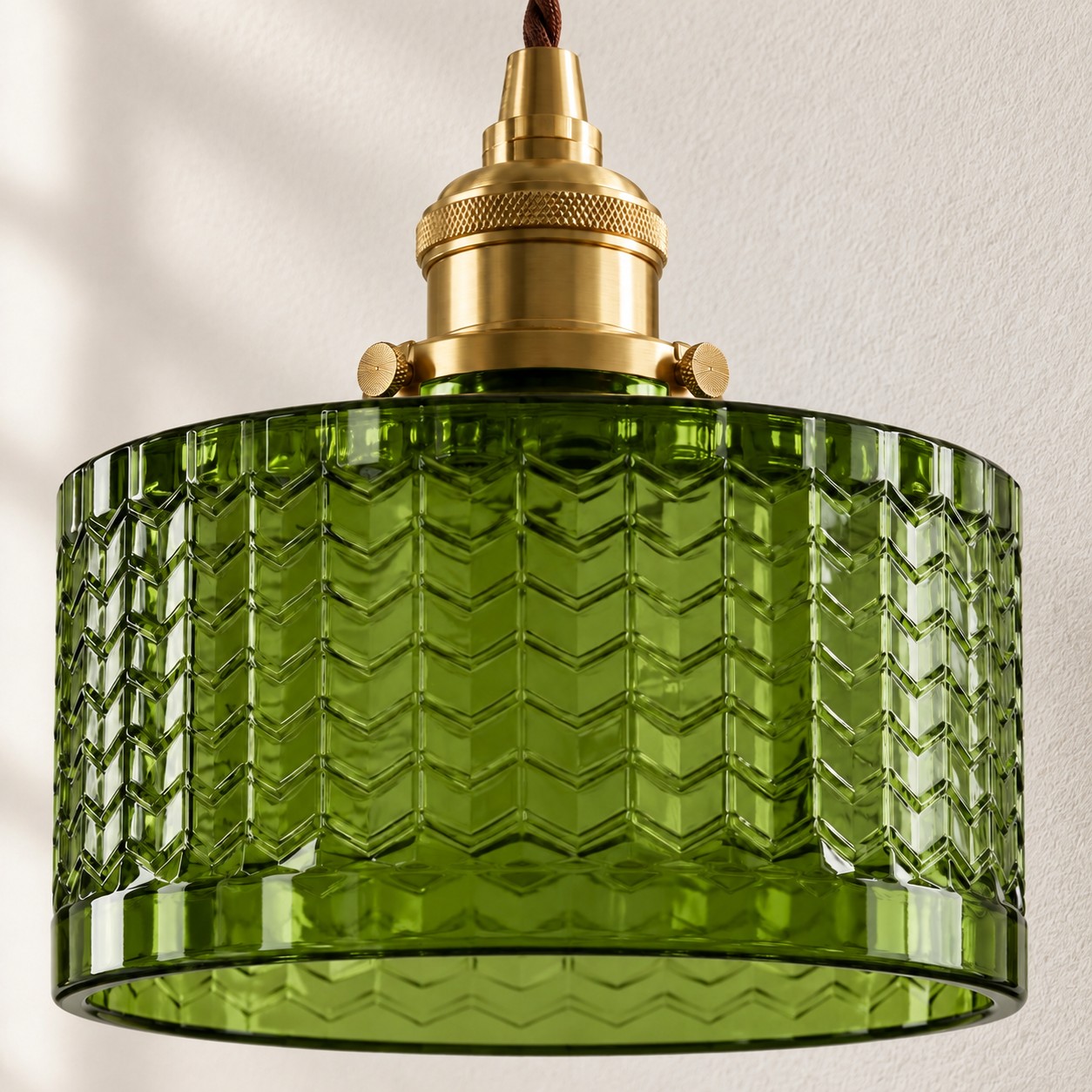 Primer plano de la pantalla completa de cristal en forma de chevrón verde oliva y del portalámparas de latón